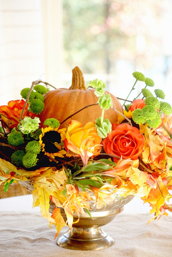 Easy Fall arrangement using a faux pumpkin, leaves and grocery store flowers.