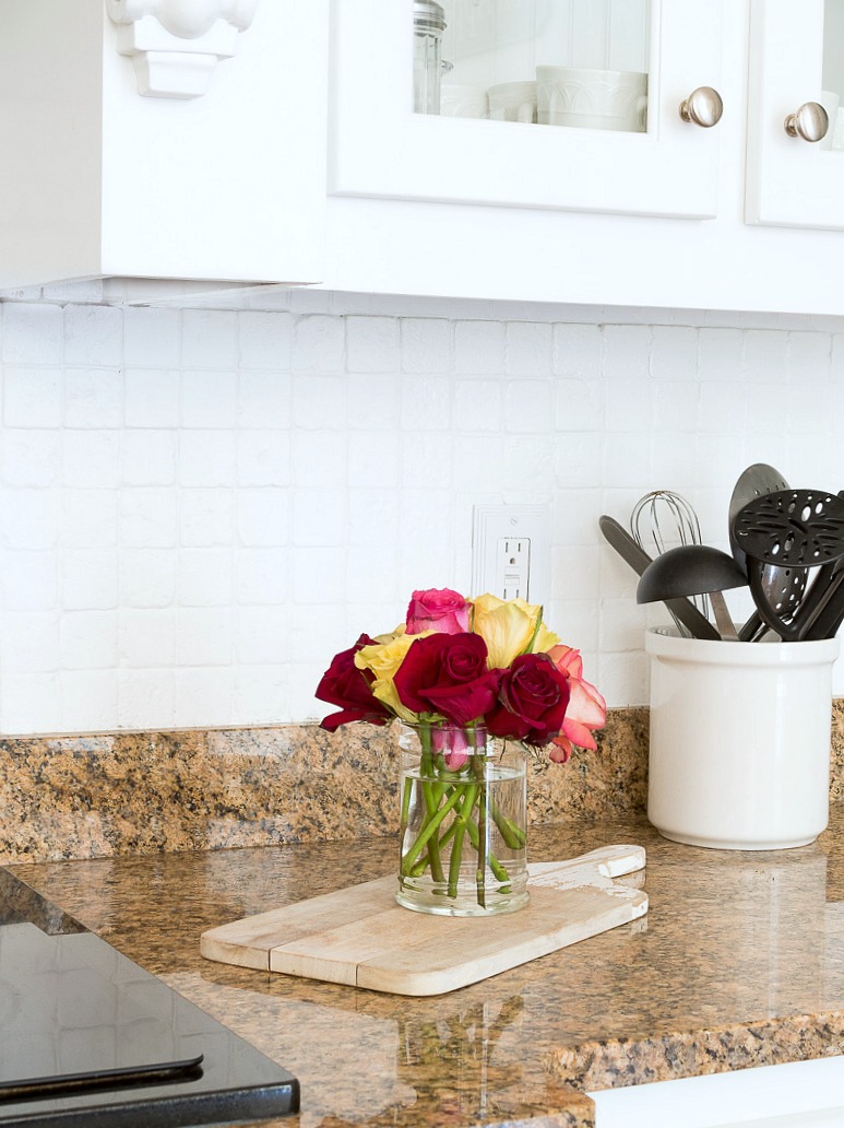 white backsplash with colored roses on cutting board in kitchen
