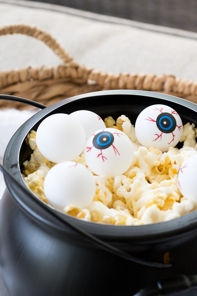 candy coated popcorn in a black cauldron.