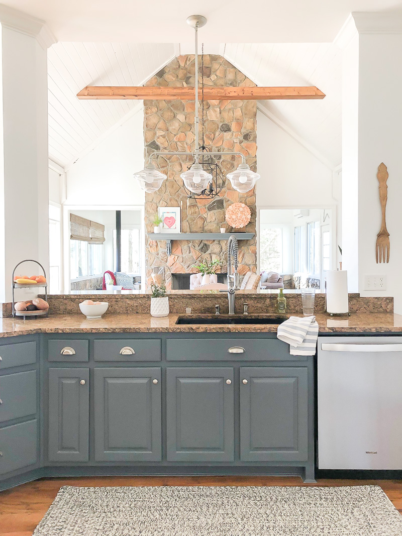 dark kitchen island with fireplace in background