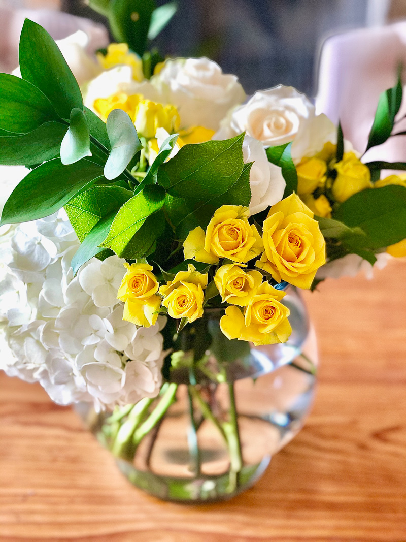 arrangement of white and yellow roses
