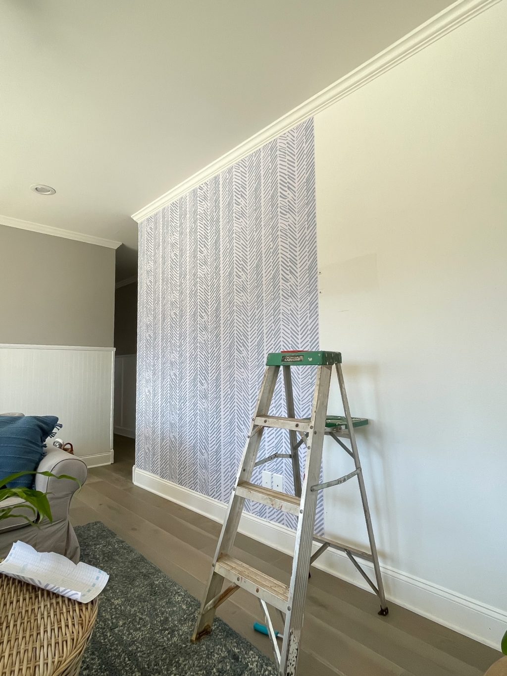 progress shot of wall being wallpapered with ladder