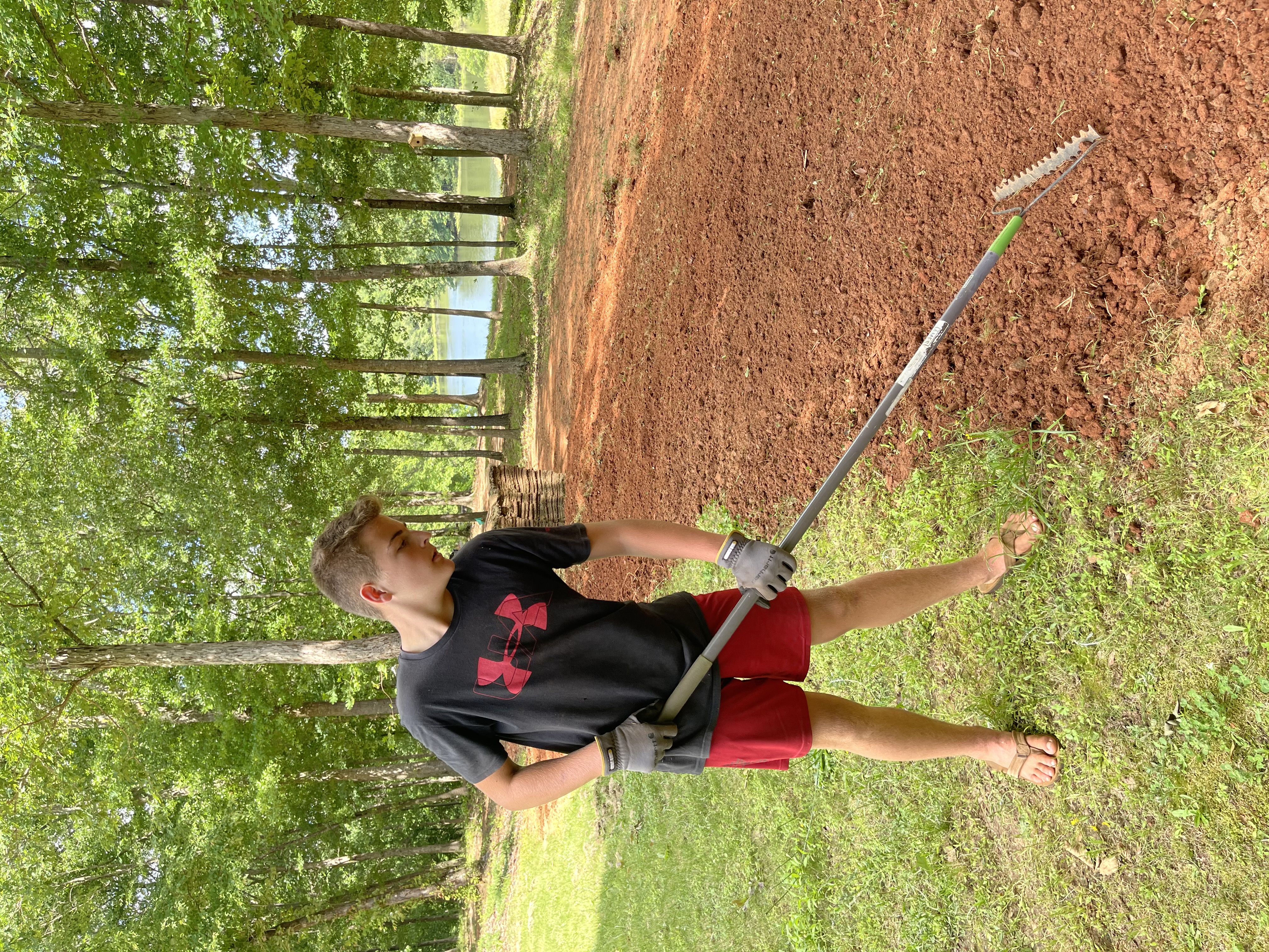 boy raking the dirt