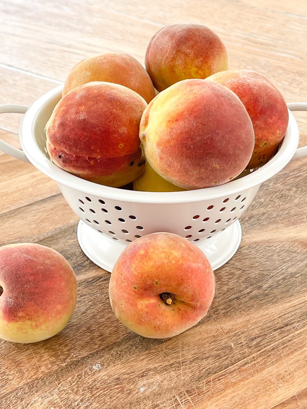 white colander with fresh peaches