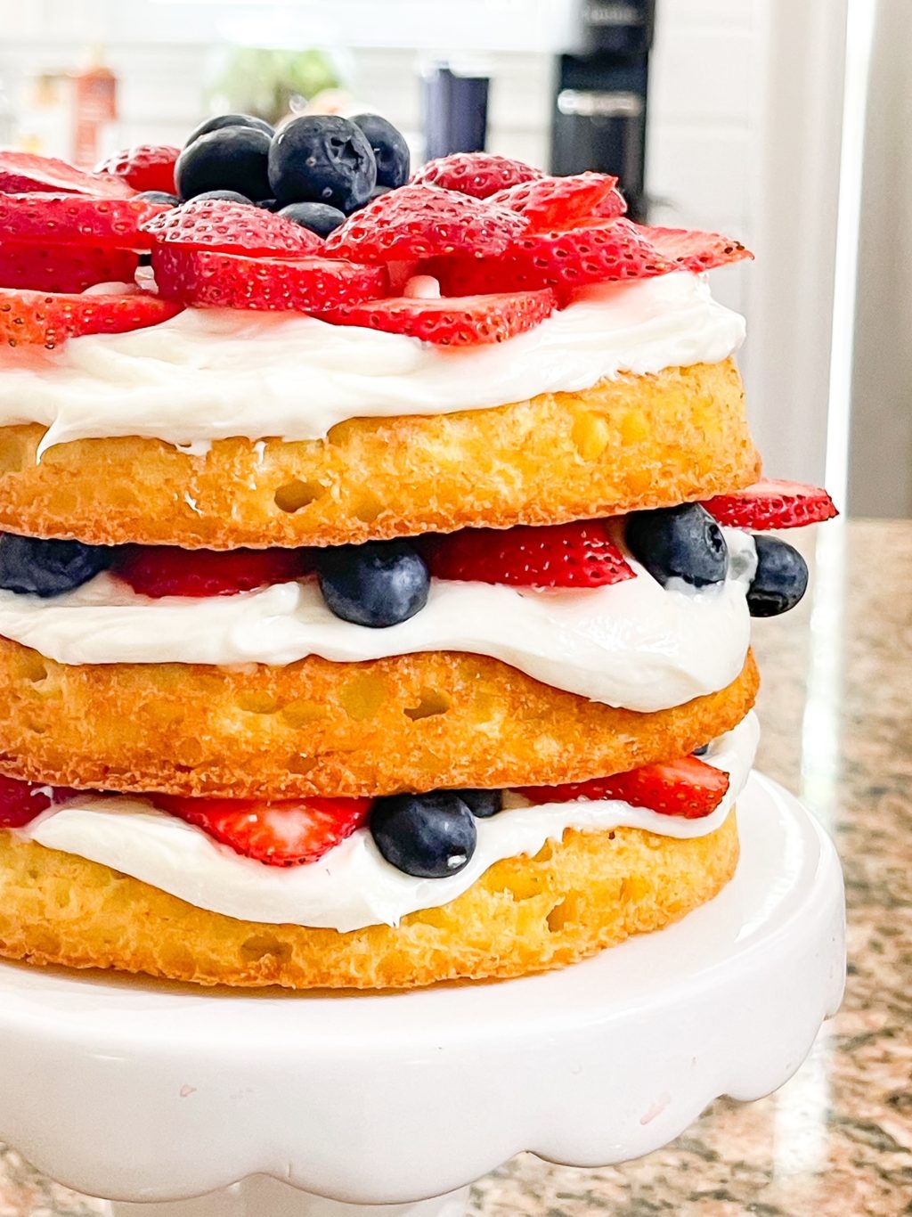 3 cake layers with blue berries and strawberries