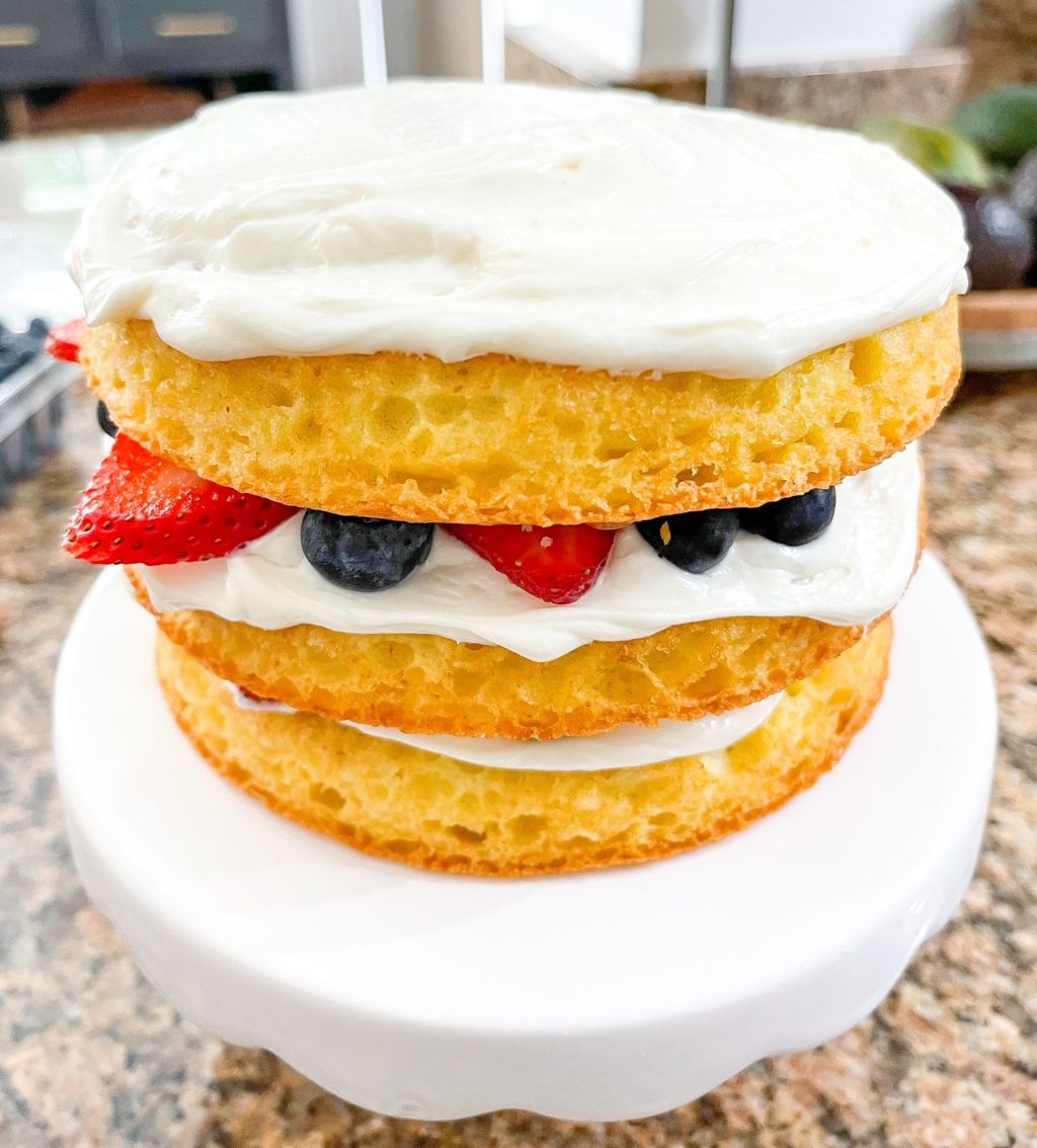 layered cake with frosting and strawberries and blueberries