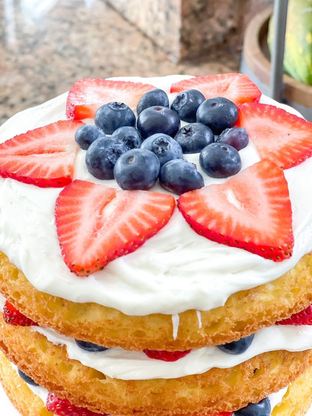 top of layered cake with blueberries in the middle