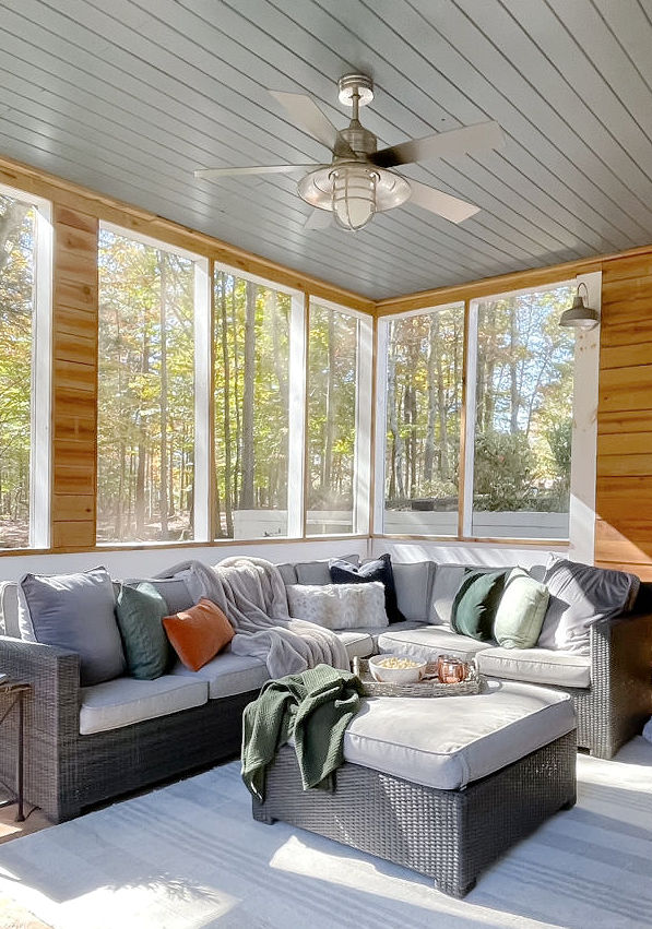 Outdoor sectional with gray, green and rust pillows.