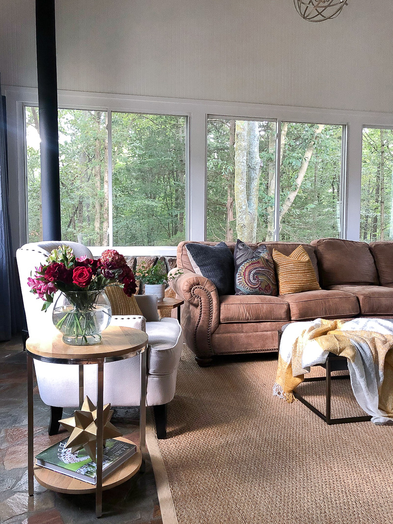 Brown section and cream colored accent chair with autumn color accents and pillows.