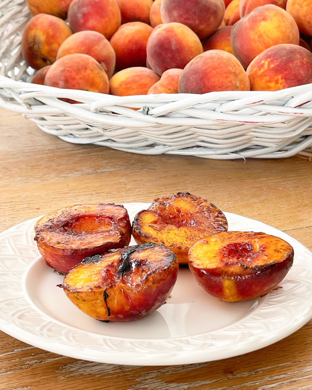 plate of fried peaches with basket of peaches in the background