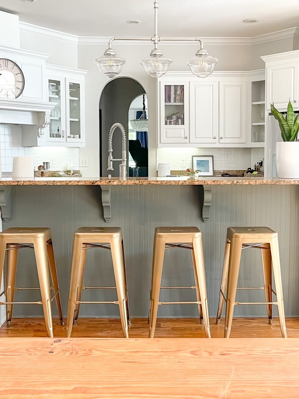 4 metal counter stools in a white kitchen.