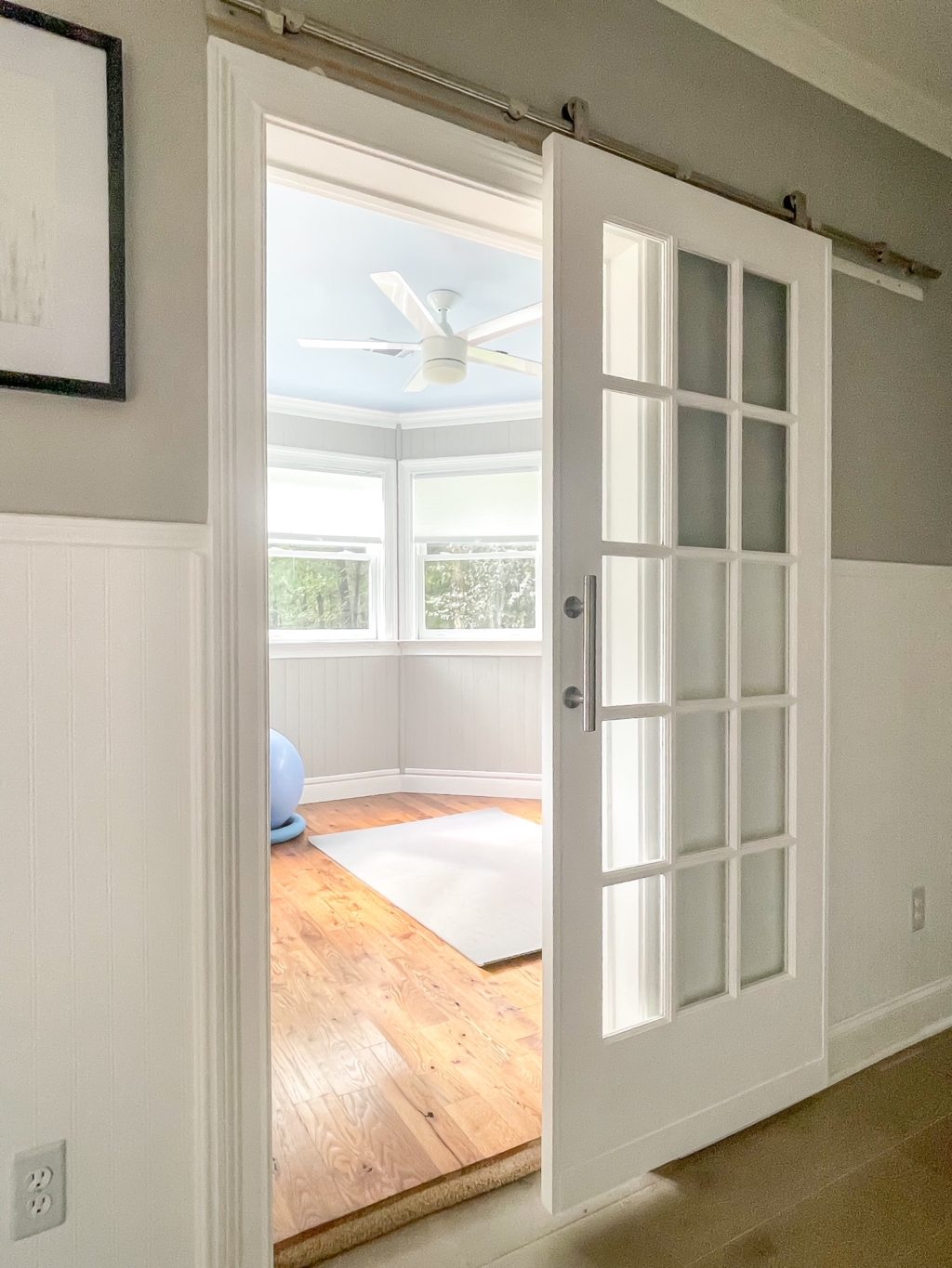 Looking into a small home gym with a sliding french door.