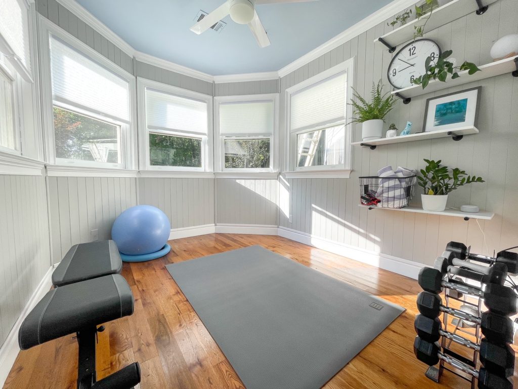 View when you walk into home gym with gray walls, blue ceiling .