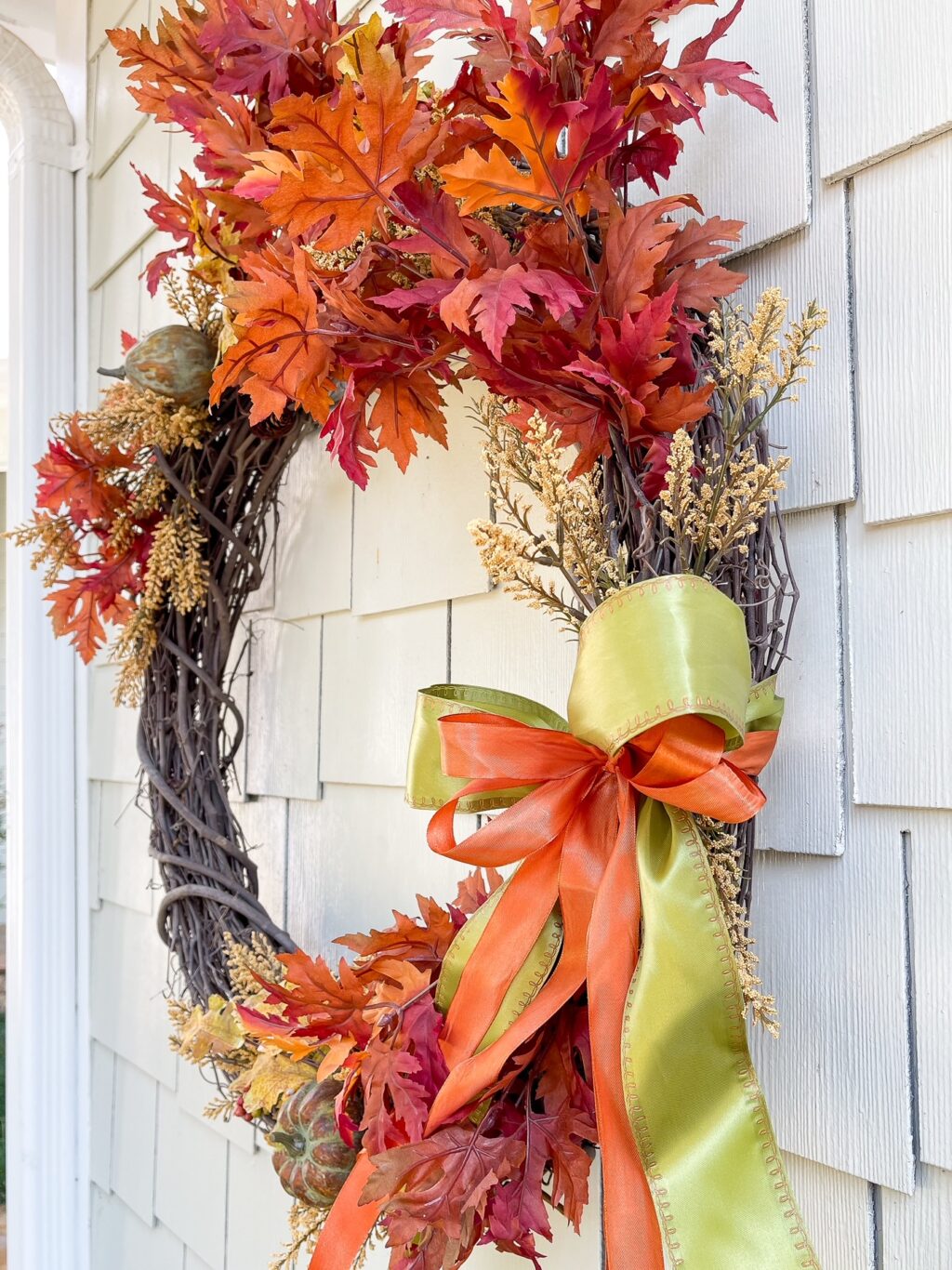 Fall wreath hanging on the outside of a home.