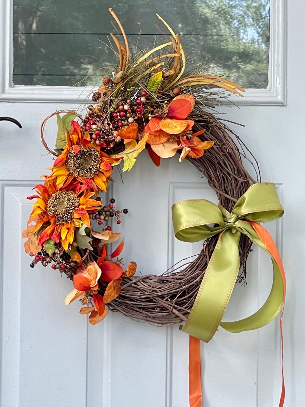 Fall wreath hanging on a blue exterior door.