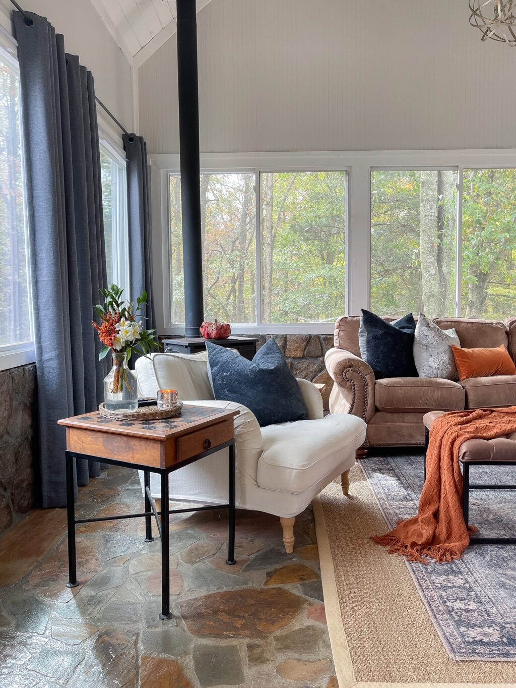 family room with rust and slate blue pillows on brown leather couch 