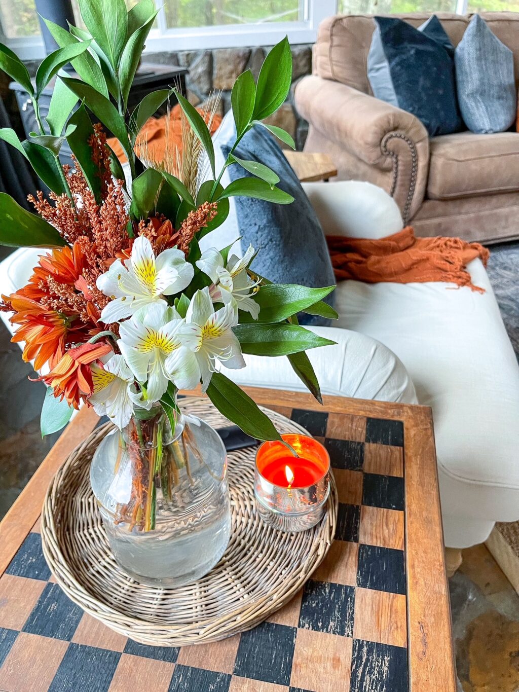 fall flower arrangement on side table with candle