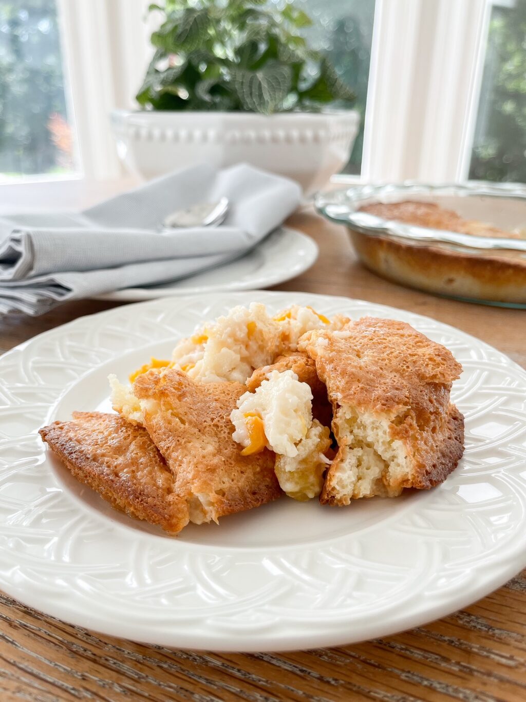 peach cobbler with fresh peaches on a white plate