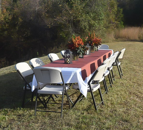 Table set up outside with centerpieces and lanterns