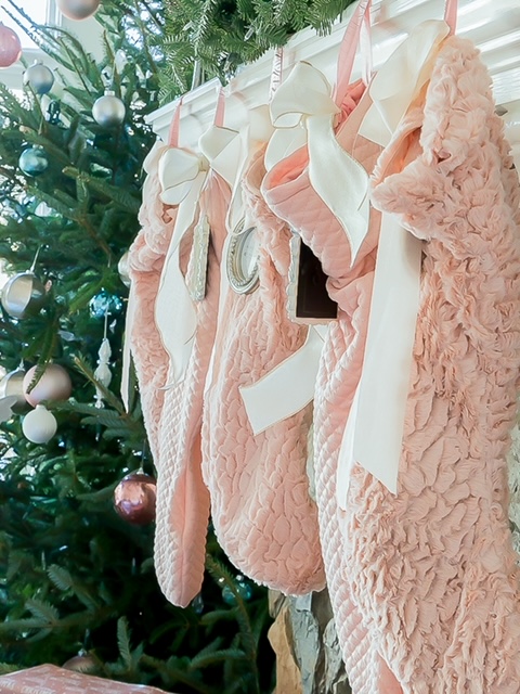 Blush pink stockings hung on a mantel
