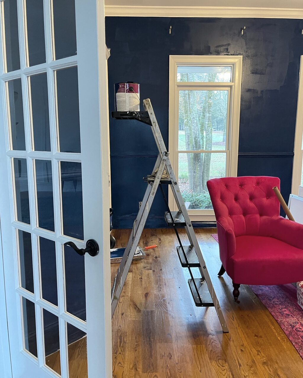Looking into home office with navy blue walls.
