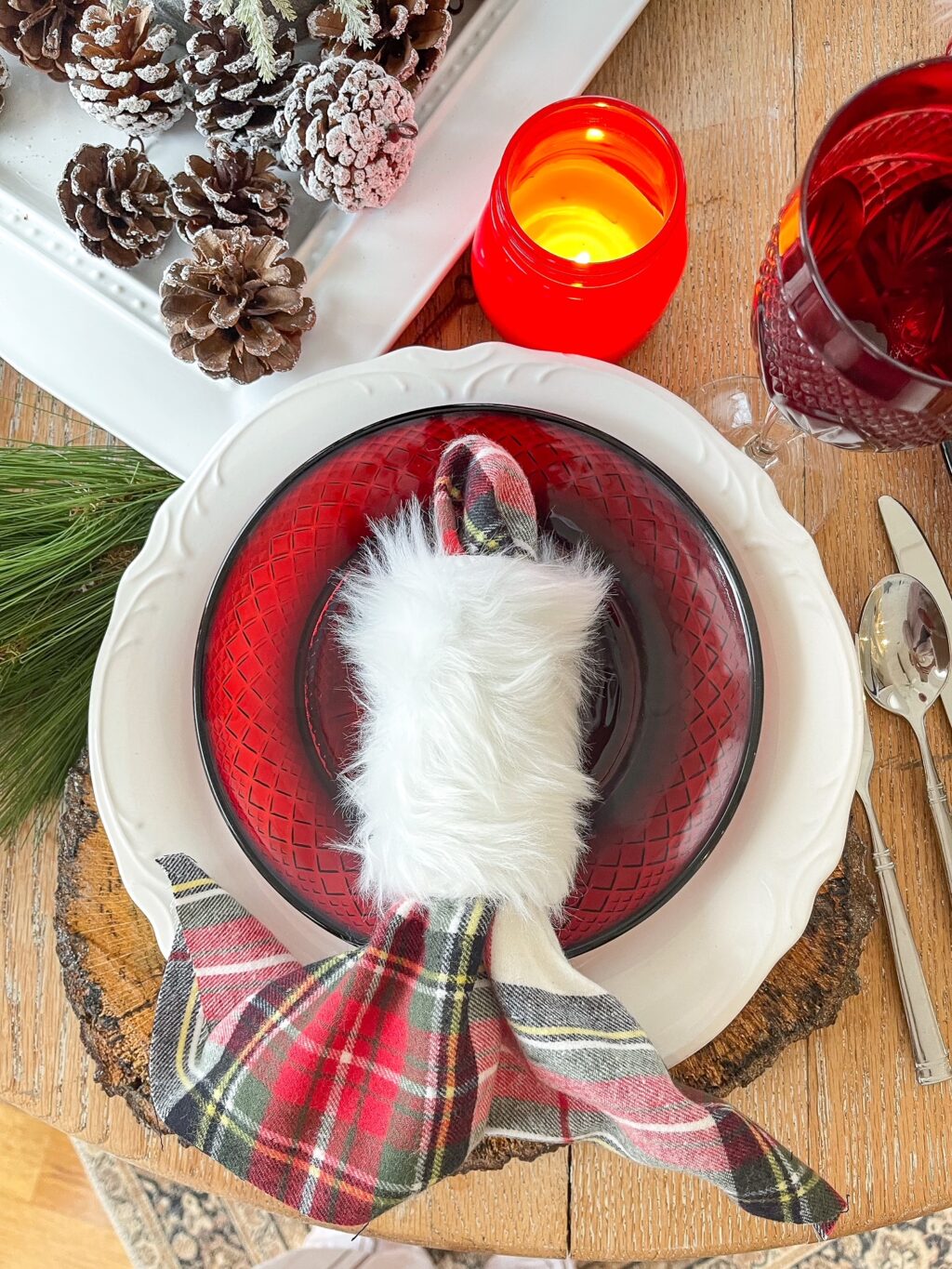 furry white napkin ring with plaid napkin on a red plate