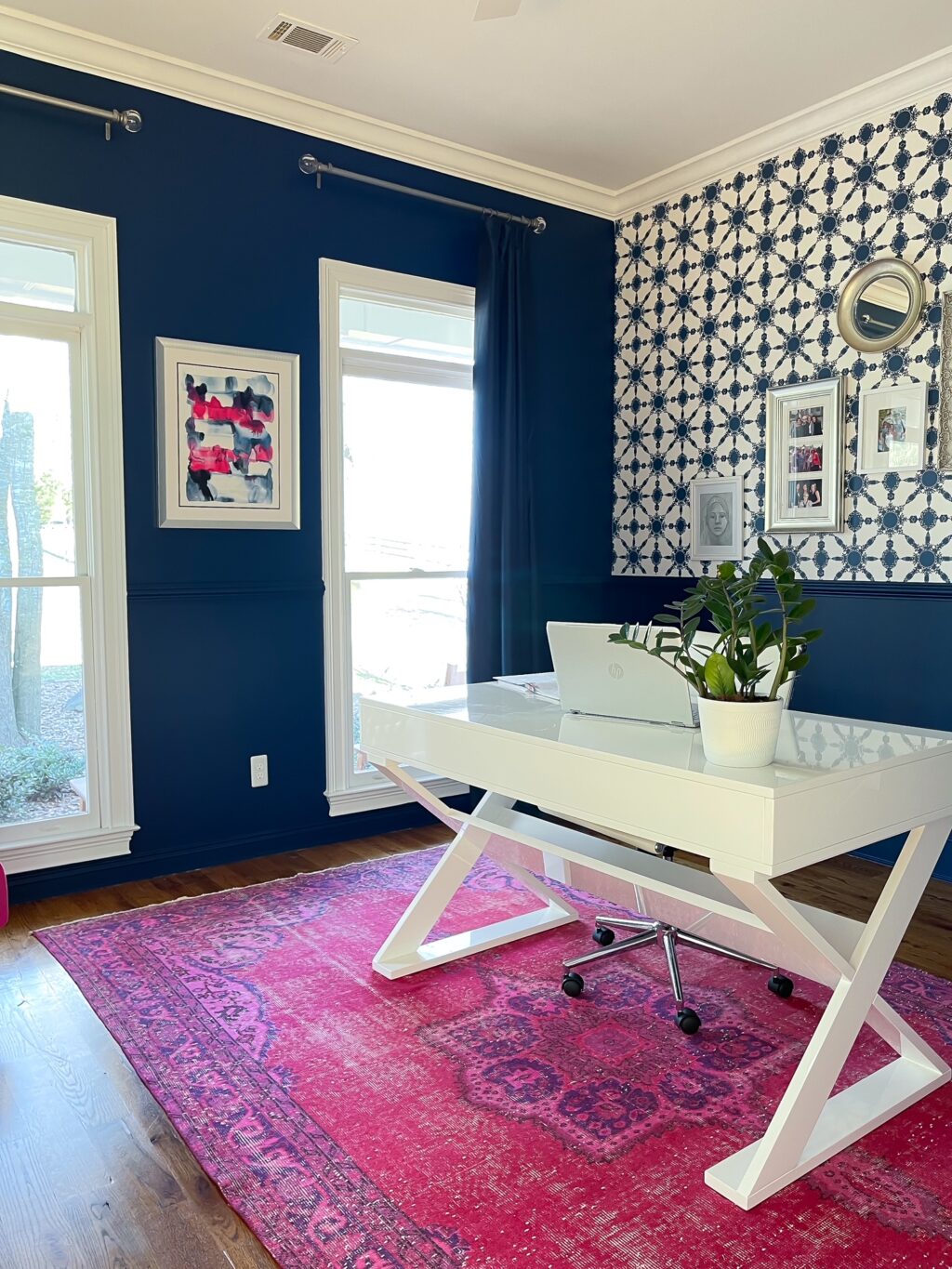 Home office with blue walls and white desk.