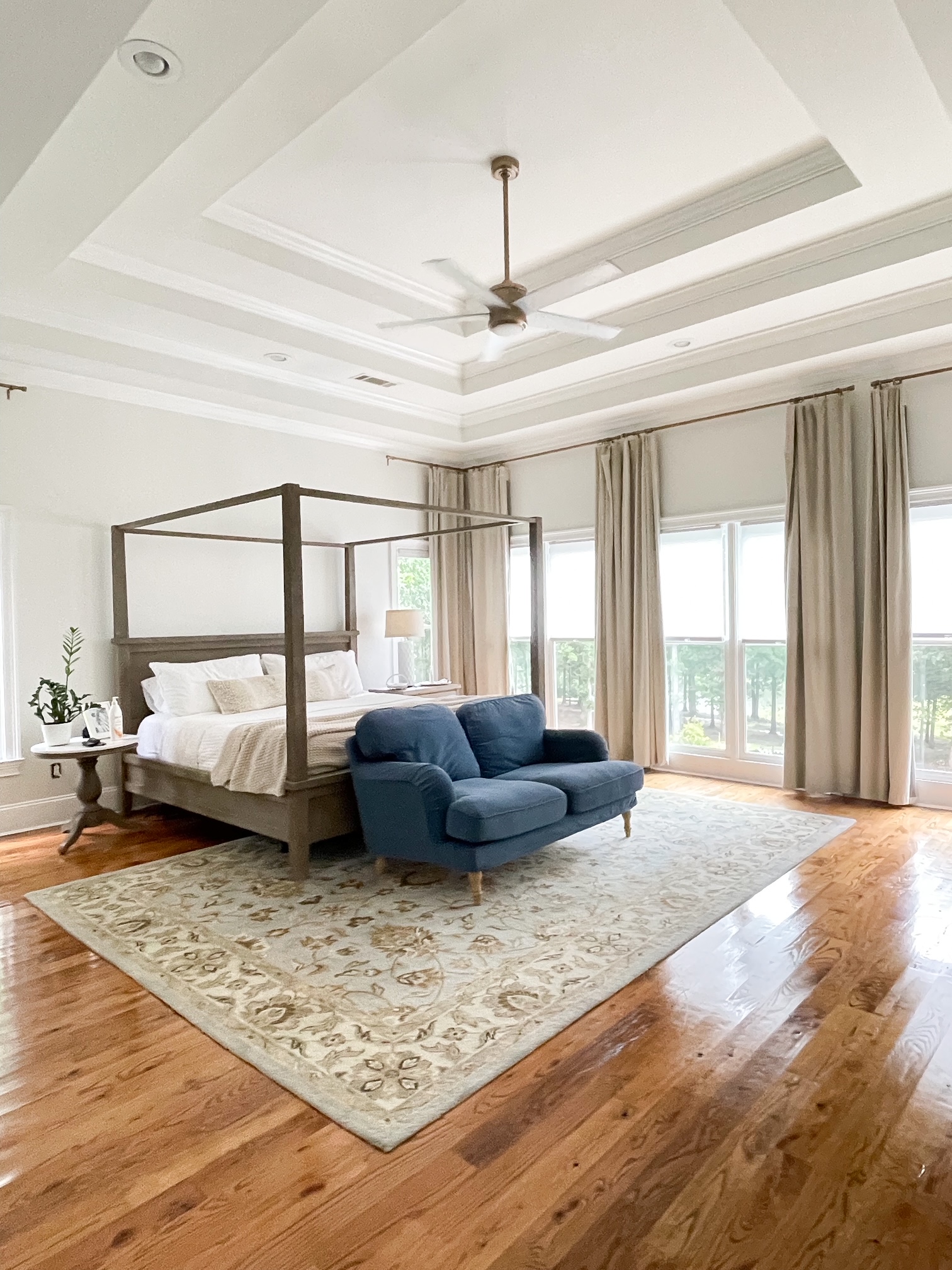 Bedroom with blue loveseat at the foot of the bed