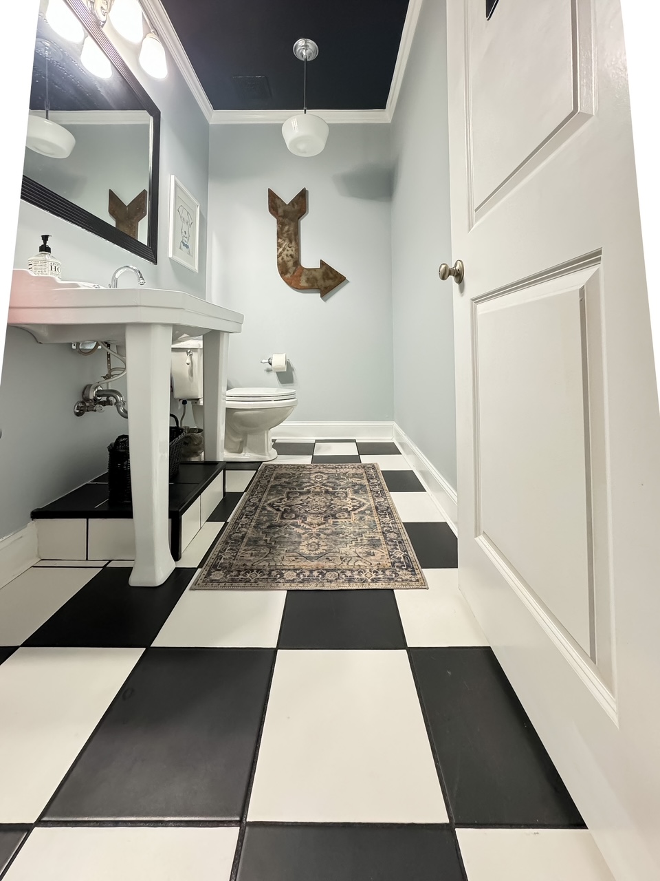 full room shot of bathroom with black and white checkered tile