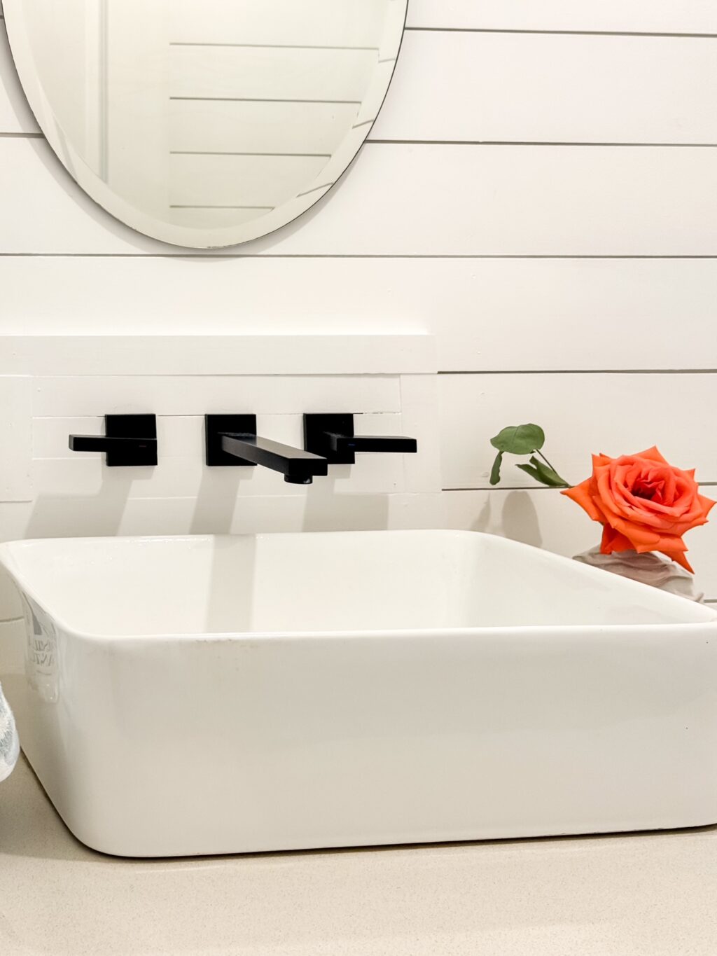Shiplap wall faucet access with white sink in a bathroom