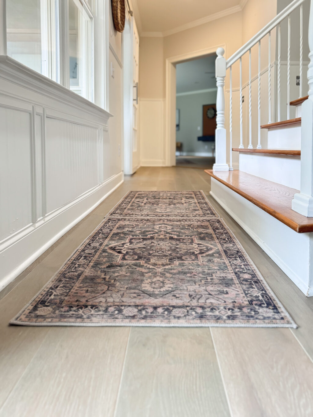 long shot of hallway, hardwood floors and rugs