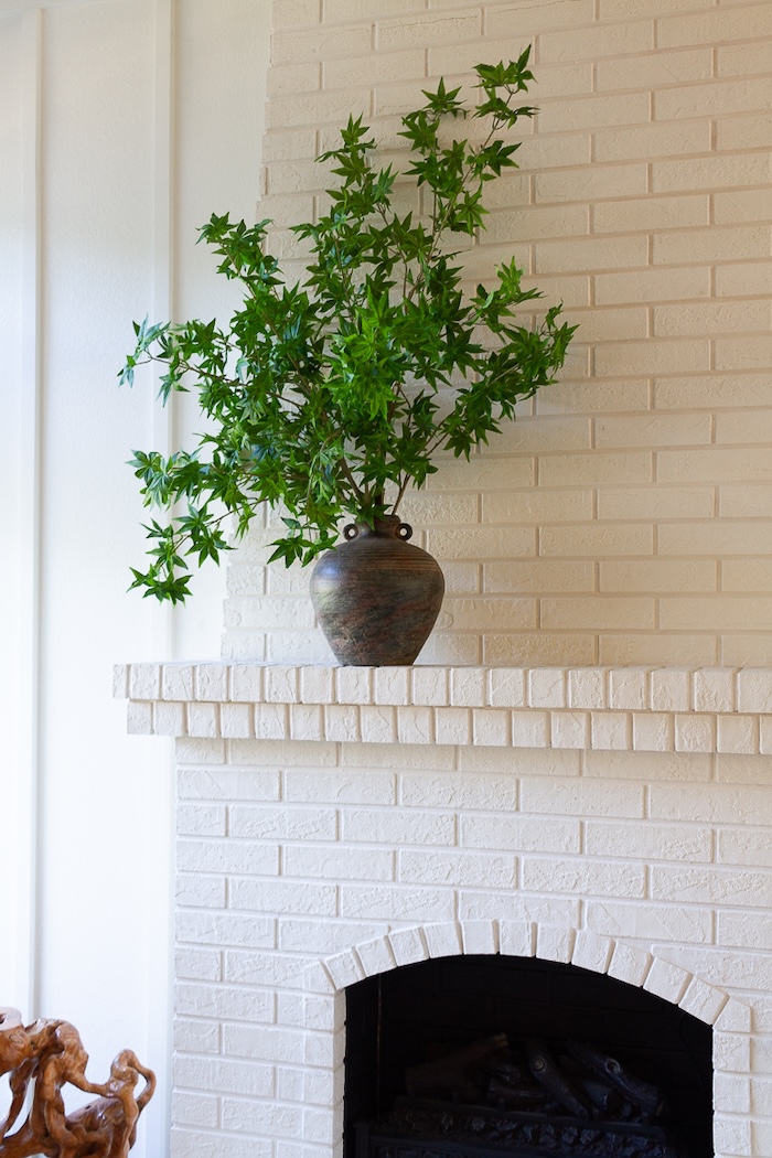 realistic faux stems styled in a ceramic vase for winter decor