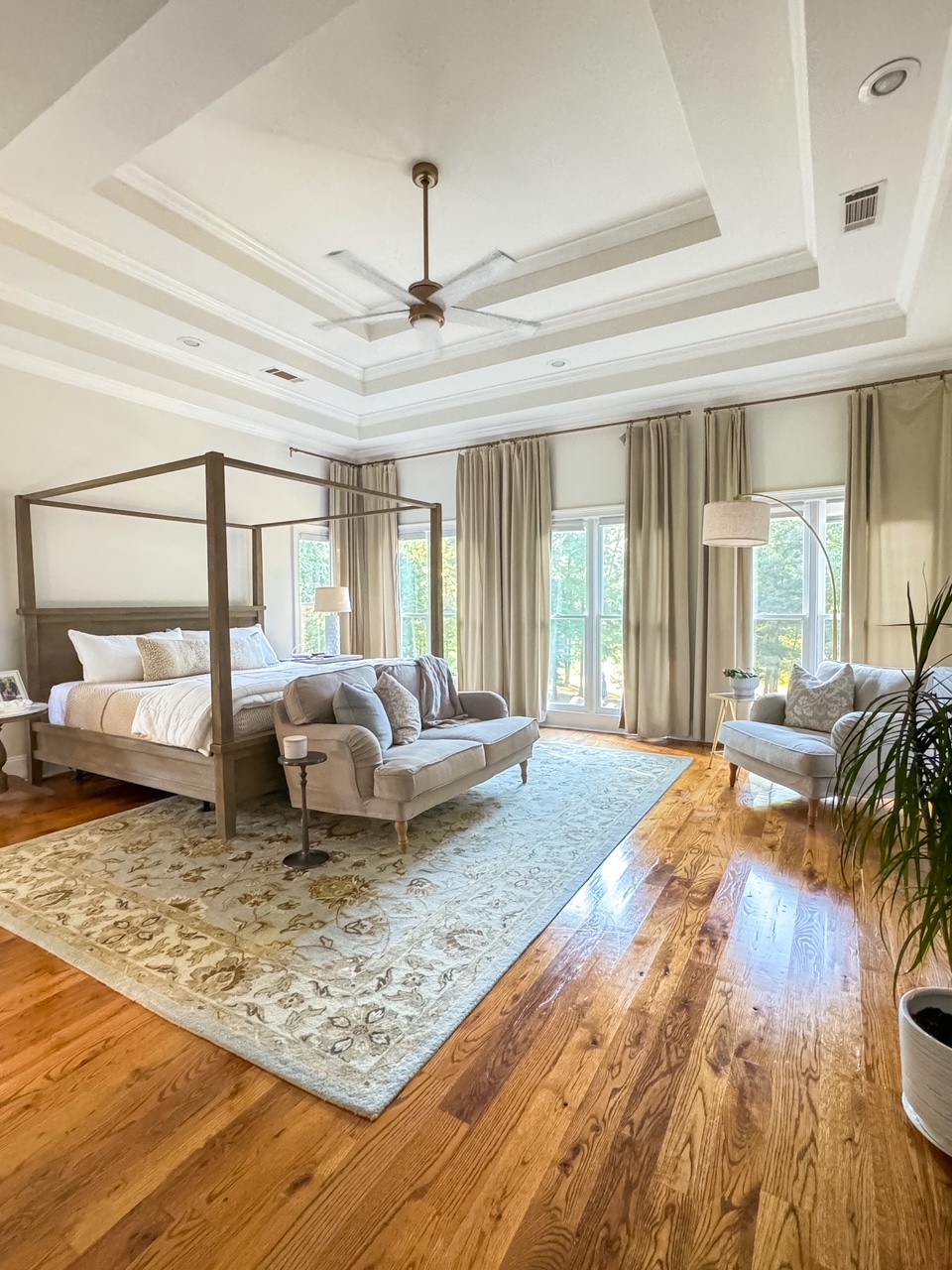 Primary bedroom design with painted ceiling and hardwood floors
