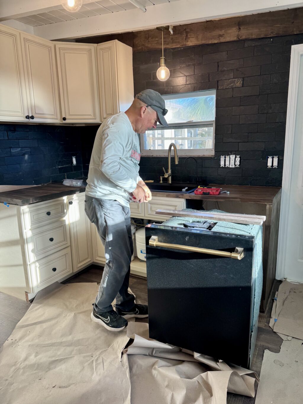 dark cottage kitchen with butcher block countertops and black appliances