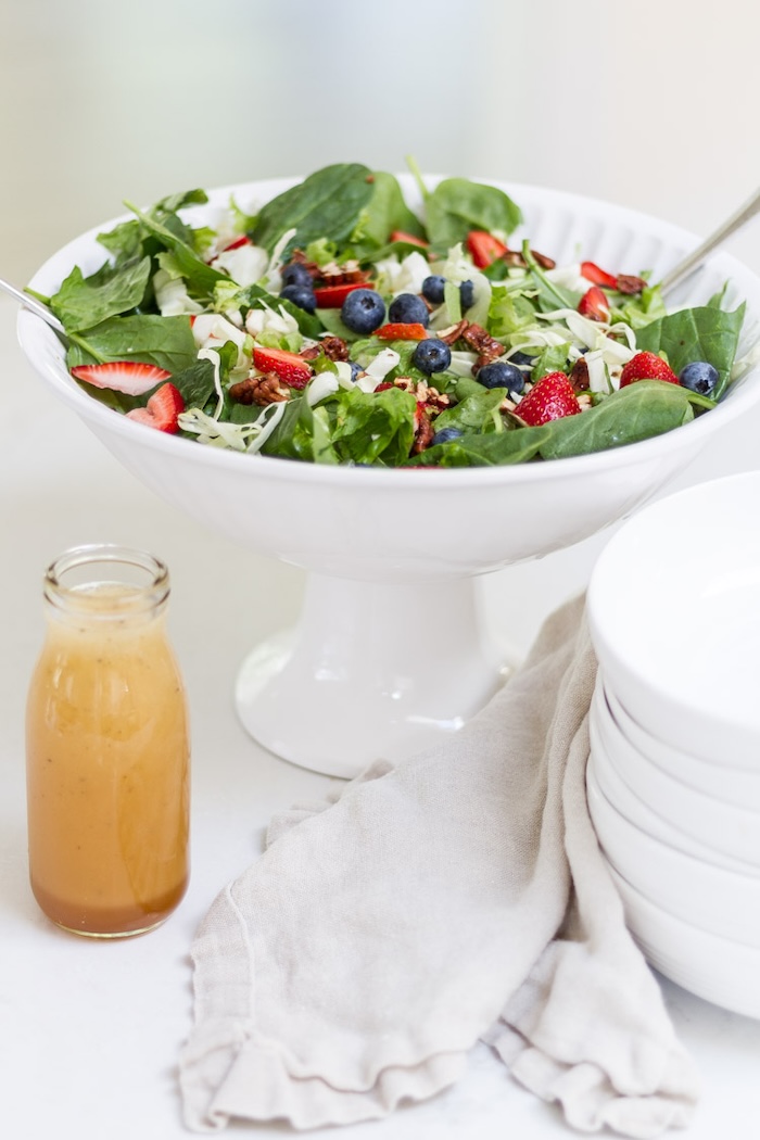 Fresh spinach and fruit summer salad with seasonal berries and homemade dressing