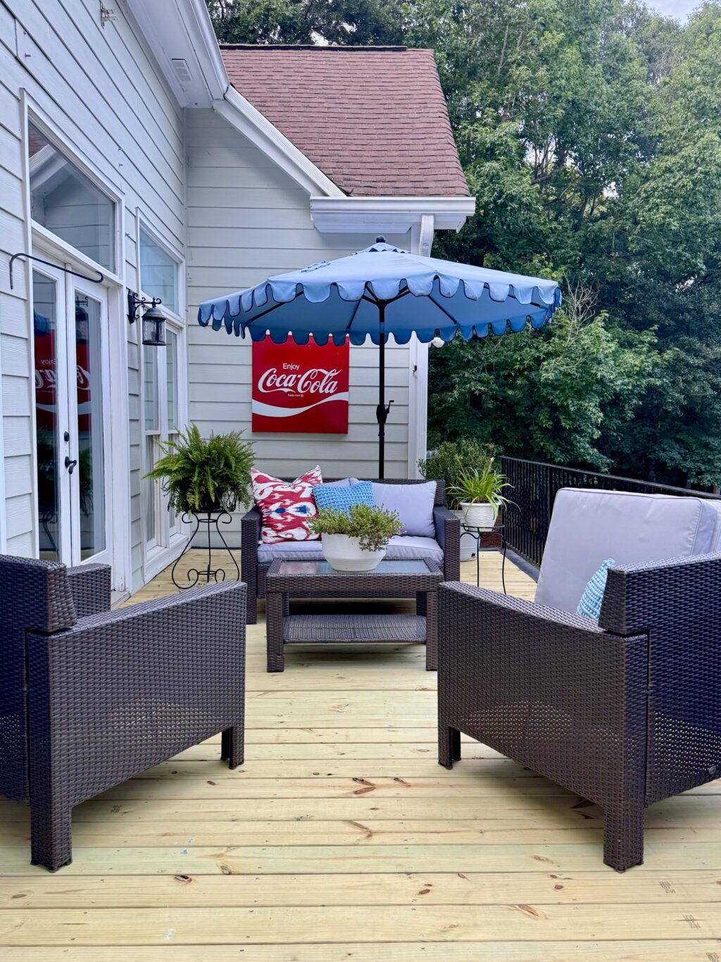 Summer outdoor deck with blue scalloped umbrella and seating area