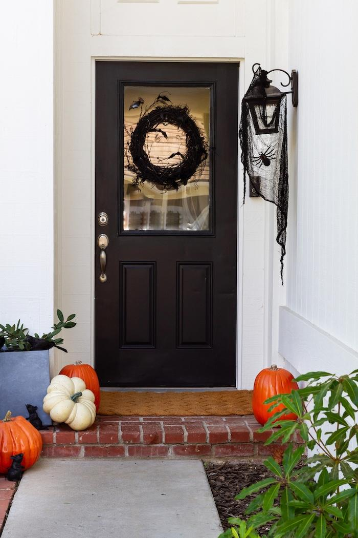 Fall decorating ideas for a Halloween front door with pumpkins and crows